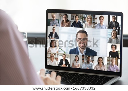 Close up of employee talk on video call on laptop with diverse colleagues, worker speak on web conference with multiracial coworkers, have online briefing with team, use Webcam on computer