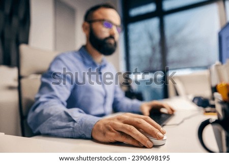 Close up of employee's hand using a computer mouse in a corporate company.