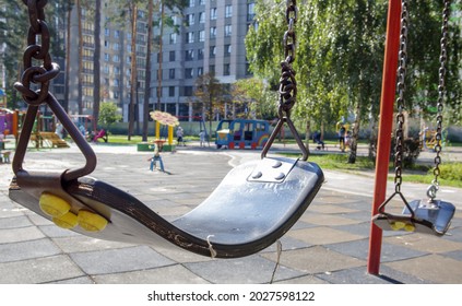 Close Up Empty Baby Swing In The Park. New Chain Swing. Set Of Black Swing Chains On A Modern Playground. Focus On The Swing In The Blurry Background. Ukraine, Kiev - August 19, 2021
