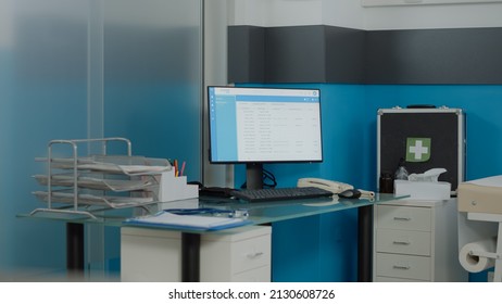 Close up of empty desk for nurses with computer monitor and document files at medical clinic. Nobody in doctors office with healthcare instruments and professional equipment for checkup