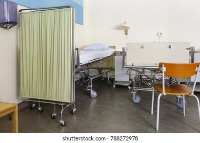 Close Up Of Empty Hospital Bed Behind Bed Screen In Hospital Ward With No People