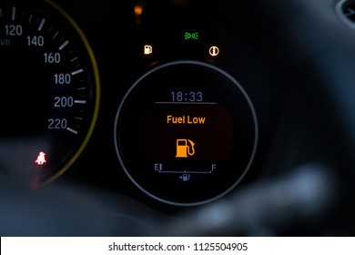 Close up empty Petrol, gasoline gauge dash board in car with digital warning sign of run out of fuel turn on on black background. Low level of fuel show on speedometer dashboard.