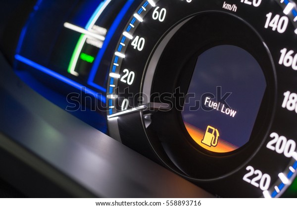 Close up empty Petrol, gasoline gauge dash board in\
car with digital warning sign of run out of fuel turn on on black\
background. Low level of fuel show on speedometer\
dashboard.Odometer Day