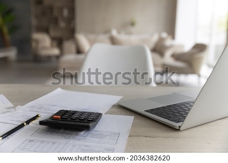 Close up empty working table with computer and paper utility bills, time for regular financial accounting, calculating domestic expenditures, summarizing taxes, planning investments or payments.