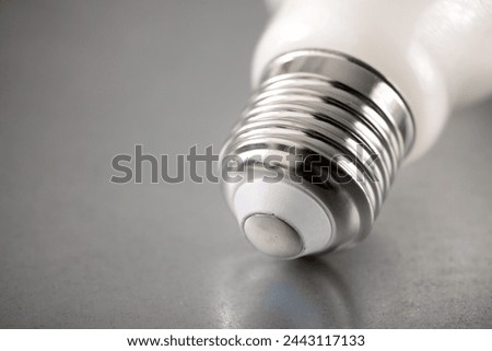 Close up of an energy-saving light bulb socket on a metal surface