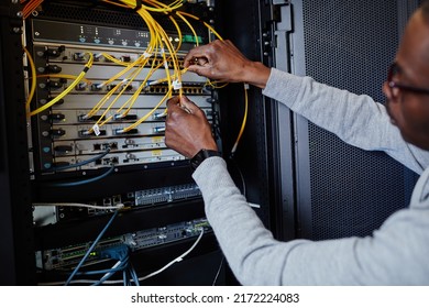 Close up of IT engineer connecting cables in server room while setting up data network, copy space
