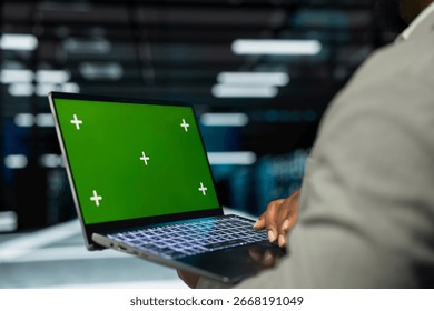 Close up of engineer in data center using isolated screen laptop to check for server performance issues. IT professional in server hub fixing errors slowing down hardware using mockup notebook