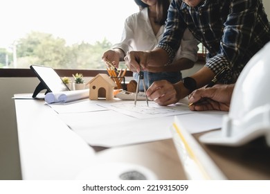 Close up of engineer hand drawing plan on blue print with architect equipment, Architects discussing at the table, team work and work flow construction concept.