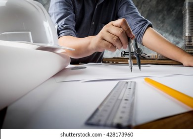 Close up of engineer hand sketching a construction project with Pencil, compass. Business meeting concept.
