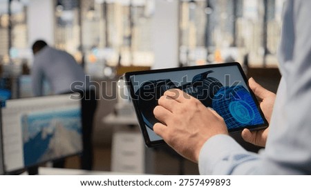 Close up of engineer using CAD app on tablet to make wind turbine sustainable, reducing carbon footprint. RD specialist swiping on touchscreen device, looks at eco friendly windmill parts, camera A
