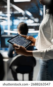 Close up of engineer using tablet, coding in data center, updating neural networks scripts. Worker in server hub programming machine learning algorithms, debugging equipment mainframes