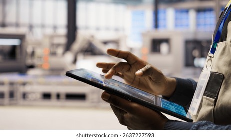 Close up of engineer using tablet to design solar panels factory layouts, utilizing CAD software and simulation tools, optimizing production systems in automated photovoltaics plant, camera A