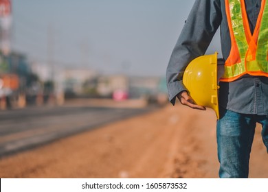 Close Up Engineering Holding Yellow Helmet Hard Hat Safety And Road Construction Background