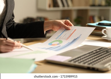 Close up of entrepreneur woman hands comparing growth graph reports on a desk at home office