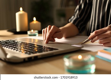 Close Up Of Entrepreneur Woman Hands Working During Power Outage With Candles Sitting On A Desk At Home Office In The Night