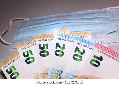 Close Up Of Euro Banknotes With Face Masks Concept Of Corona Virus In Europe