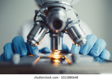 Close up of examining of test sample under the microscope in laboratory.