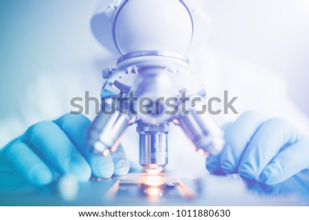 Close up of examining of test sample under the microscope in laboratory.