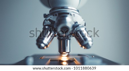 Close up of examining of test sample under the microscope in laboratory.