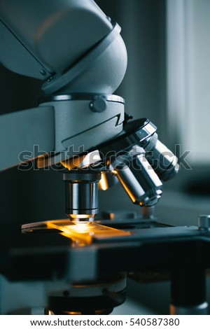 Close up of examining of test sample under the microscope in laboratory.