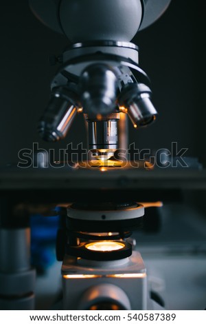 Close up of examining of test sample under the microscope in laboratory.