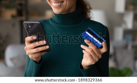 Close up of excited young Caucasian woman hold smartphone shop online with credit card. Happy female client or buyer pay buy on internet with cellphone using secure banking system on gadget.