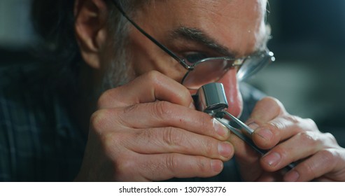 Close up of experienced goldsmith controlling a quality of diamond stone, selected for making jewels in workshop. Concept of jewelry,luxury,goldsmith, diamonds, brilliance.