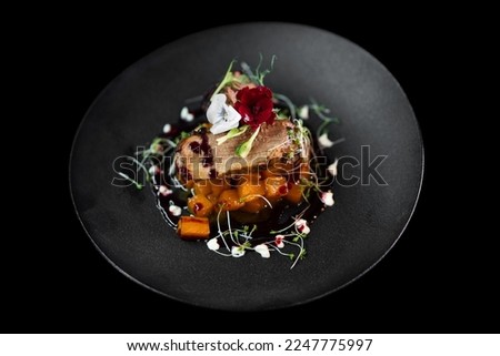 close up of an exquisite serving of a special dish from the chef on a black plate