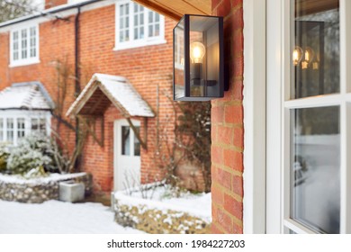 Close Up Of Exterior Lamp Outside Snow Covered House In Winter