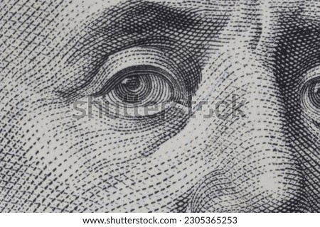 close up of eye of Benjamin Franklin on one hundred US dollars banknote