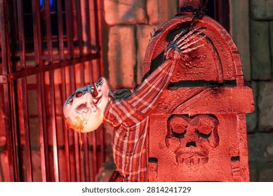 Close up eye level dramatic shot of hanging Halloween decorations and a skeleton prop in a themed attraction