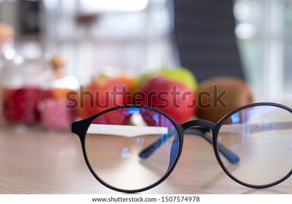 Close up eyeglasses with fruits & food\
supplement in background. The food supplements is for eyes care\
& remedy. To avoid eyes problems, patient need good nutrition.\
Healthcare & medical car\
concept.