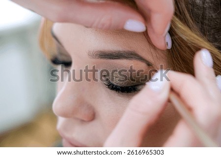 close up eyes Makeup, Make up in process , beautician applies makeup eyeshadows in bright professional studio, Beautiful woman face, Hand of master in beauty salon, wedding preparation