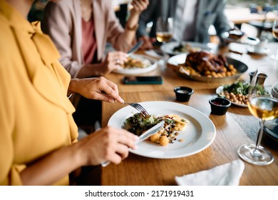 Close up f businesswoman eating lunch with colleagues in restaurant. - Powered by Shutterstock