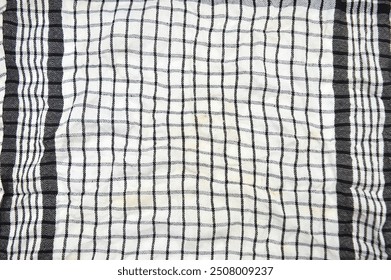 A close up of a fabric with a checkered pattern of white and black lines