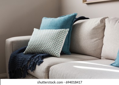 Close Up Of A Fabric Sofa With Styled Cushions And Throw