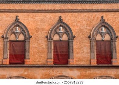 Close up of facade of historic building with Gothic-style architectural details, arched windows, bust sculptures on Piazza Santo Stefano in Bologna old town, Emilia Romagna, Italy - Powered by Shutterstock