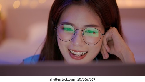 Close Up face of a asian beautiful young woman looking at laptop in evening - The light from monitor is reflected on her glasses with shopping online web