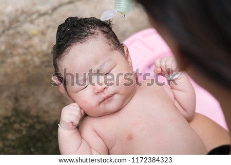 close up face of asian newborn take a bath with her mother