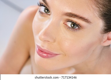 Close up of the face of a beautiful girl with perfect skin and clean from all impurities and with her hands touching the delicate skin in the sense of morbid and perfection. 