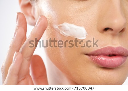 Close up of the face of a beautiful girl with perfect skin and clean all impurities thanks to moisturizing creams both anti-aging and night and day. Concept of beauty, creams,skincare and clear.
