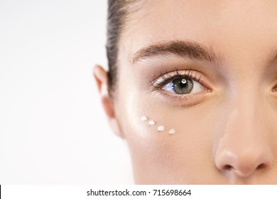 Close up of the face of a beautiful woman with perfect skin thanks to creams to keep young and cream contour anti-aging and wrinkle eyes. Concept of: beauty, cleanliness and perfection