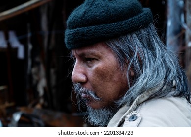 Close Up The Face And Eyes Of A Homeless Old Man Leaning Against The Wall Of An Old Building, Waiting For Held From Others. Homeless Not Have A Home As On The Roadside Are Their Beds.