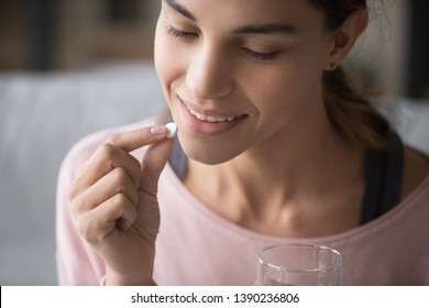 Close Up Face Of Healthy Attractive Woman Holding Pill And Glass Of Water Everyday Taking Omega 3, Probiotics, Multivitamin Vitamin Complex And Supplements For Beauty Skin And Body Health Care Concept