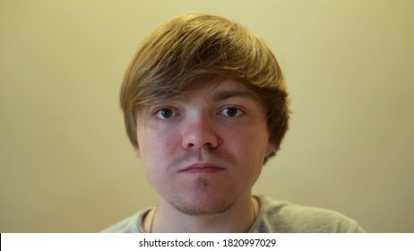 Close Up Of Face Of A Man Chewing Food. Concept. Blond Man Looking Into The Camera With His Mouths Chewing Some Food Isolated On Beige Background.