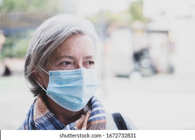 close up of face of mature woman looking away wearing medical mask prevention coronavirus or covid-19 or another type of virus - senior portrait and close up with medicine mask on the face 