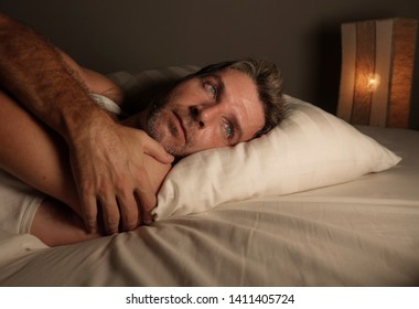 Close Up Face Portrait Of Attractive Sad And Thoughtful Man Lying On Bed Awake Late At Night Thinking Feeling Worried And Concerned After Divorce Or Life Problem In Dramatic Light