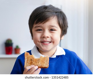 Close Up Face Preschool Boy Eating Honey On Toasted For His Breakfast Before Go To School, Cropped Shot Healthy Child Eating Butter On Bread In The Morning, Healthy Food For Kid Concept