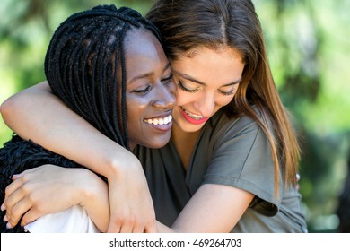 Close up face shot portrait of two multiracial friends showing affection outdoors.