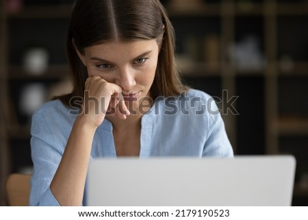 Close up face tired unmotivated woman, office employee student sit at desk staring at laptop screen feels exhausted, hopeless, unable to complete task. Long hard workday, lack of understanding concept